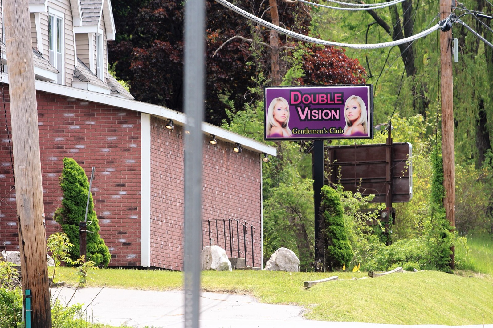 Double Vision Gentlemen's Club sign beside the brick building on Route 9