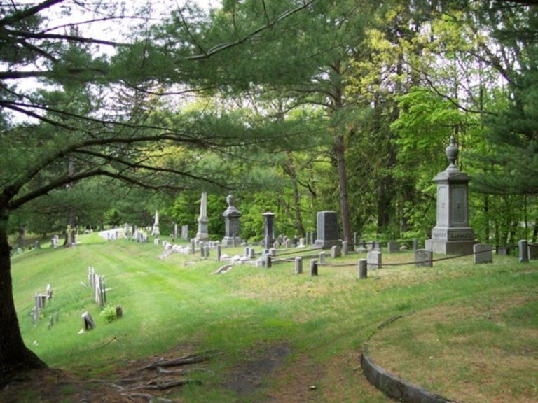 Gravestones and tall monuments on a grassy hillside at Jonesville Cemetery